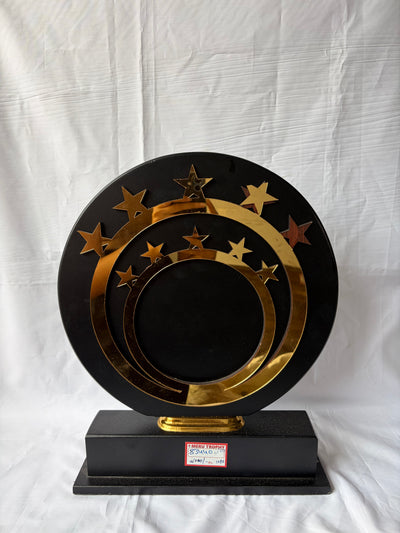 Elegant 83440 decorative plaques with gold star accents and concentric rings on a black circular stand for awards.